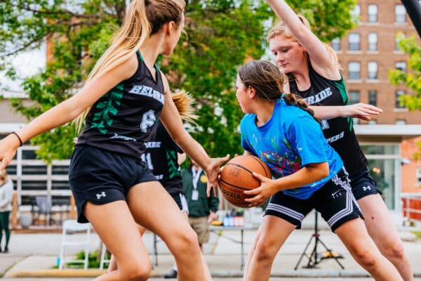Youth basketball players dribbling and defending during a street basketball event in Uptown Butte, Montana.