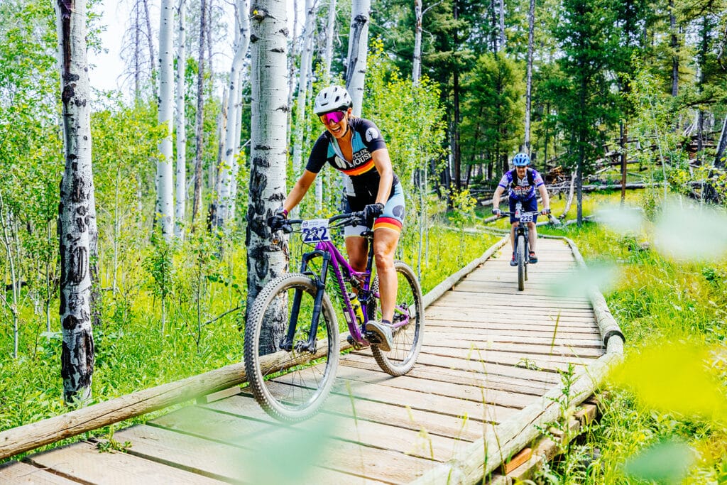 Butte photography of Butte 100 racer smiling at camera while riding bike