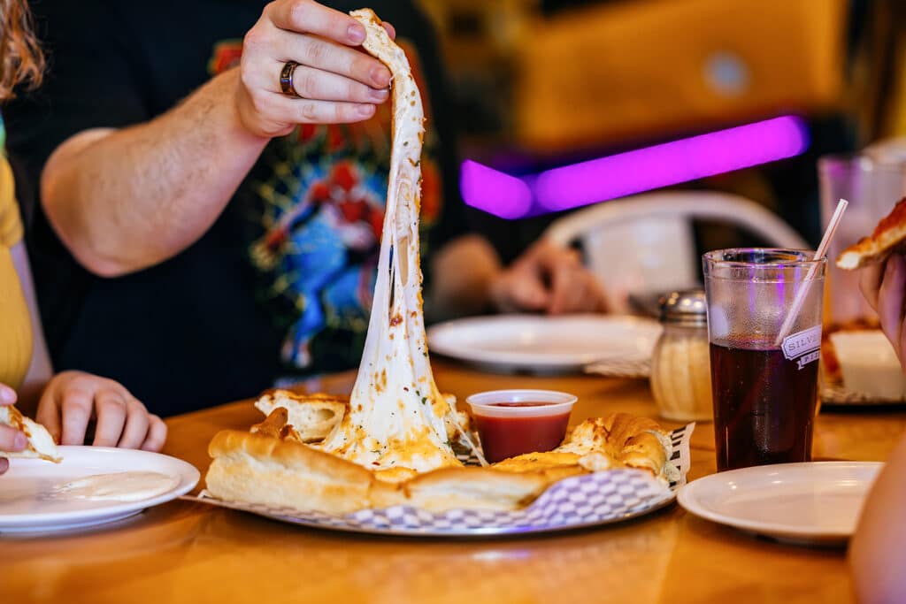Butte photography for commercial purposes: person pulling an extra cheesy slice of pizza