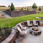 Custom landscape design featuring stonework and integrated planting beds