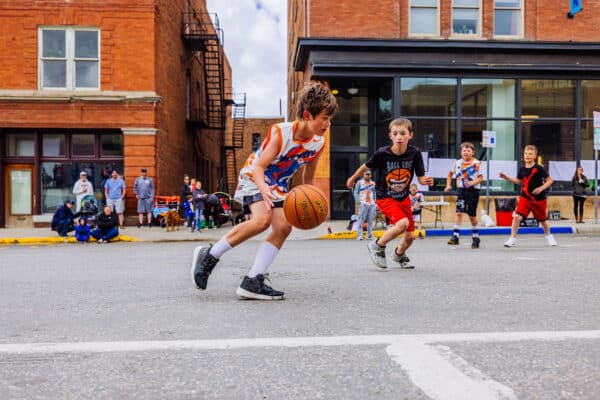Youth basketball players competing during a street basketball game at Uptown Hoops in Butte, Montana.