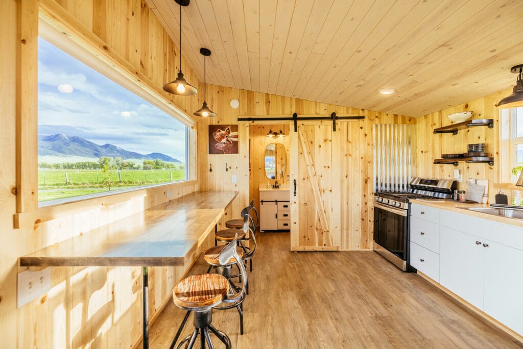 Montana Short term rental photography showing modern interior of a small cabin with large window looking at mountains