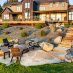 Fire pit surrounded by stonework and landscaped plantings at a modern Montana home