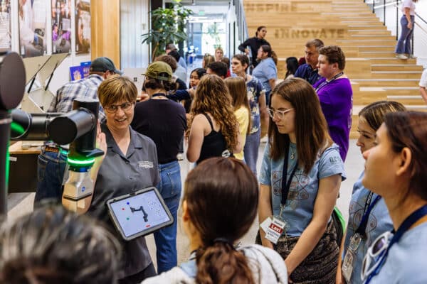 Instructor demonstrates a robotic arm to students during a hands-on STEM learning event in Bozeman, Montana.