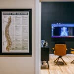 Brand photography of a chiropractic consultation room in Butte, Montana, featuring patient seating and diagnostic imaging.