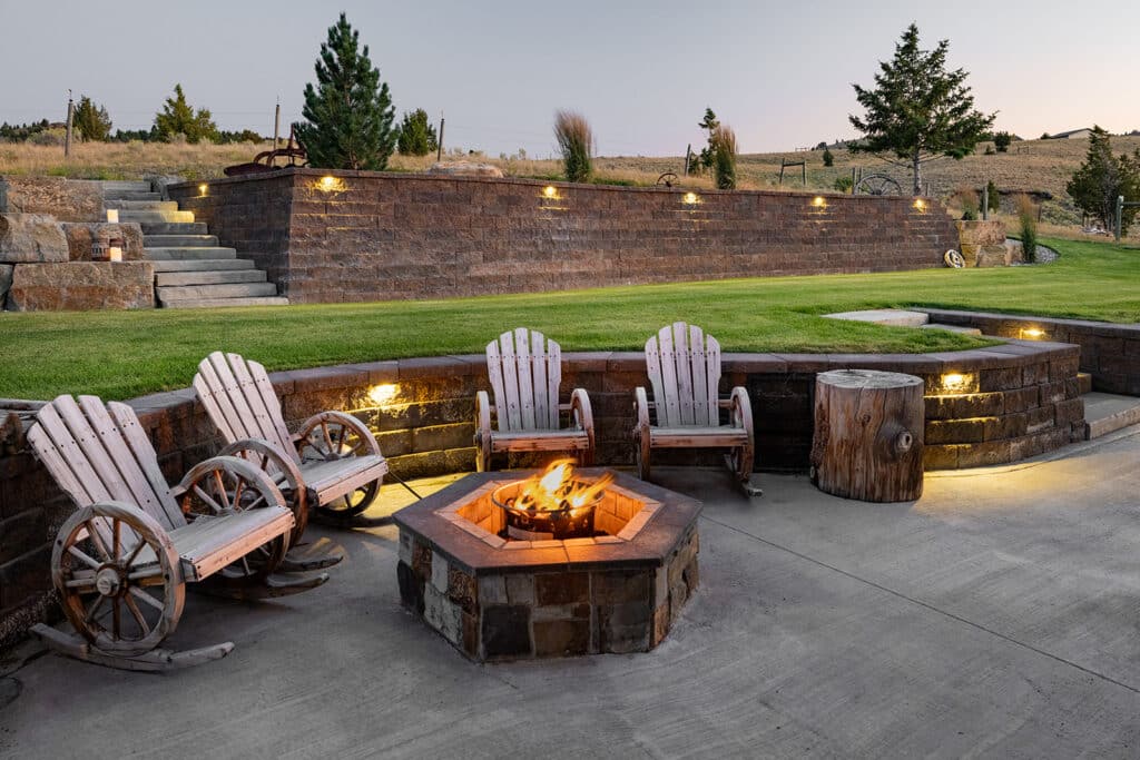Outdoor fire pit with surrounding stone landscape design at a modern Montana residence