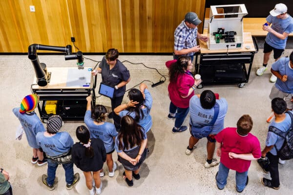 Students gather around interactive robotics stations during a STEM education event in Bozeman, Montana, photographed for Finn Partners.