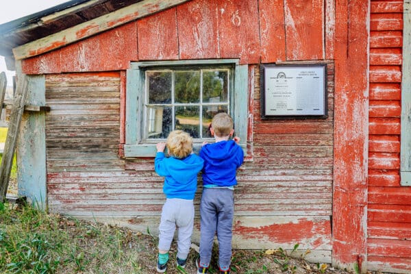 Children peering through historic building window in Virginia City