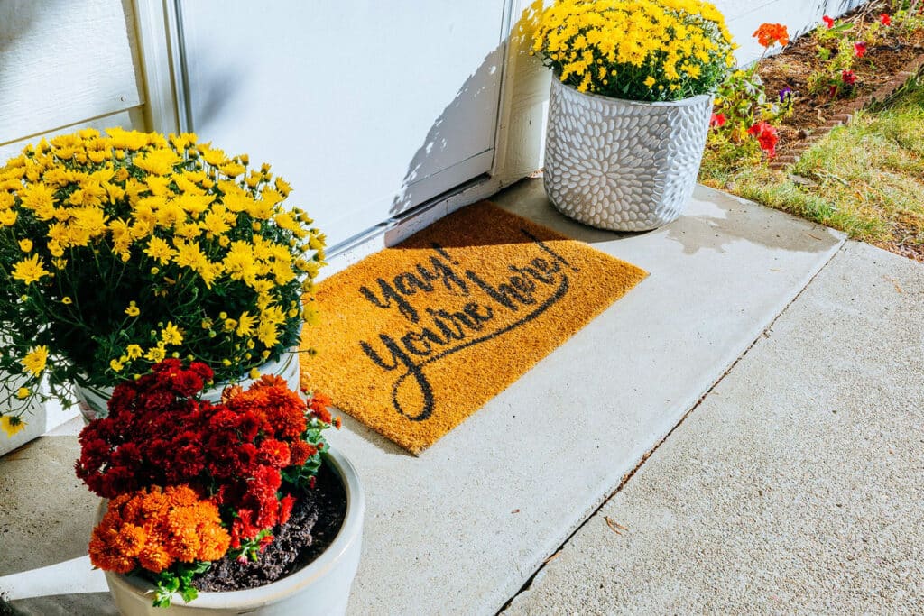 Welcoming entry detail at a Montana Airbnb with seasonal flowers and front door styling.