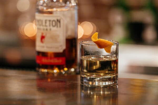 Pendleton whisky with an orange twist ontop of a bartop